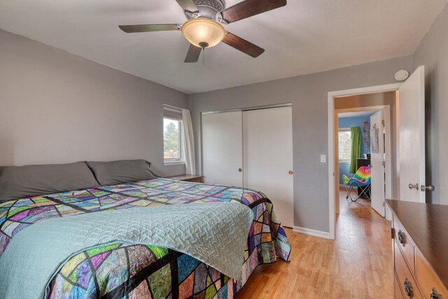 bedroom featuring light wood-style floors, a closet, a ceiling fan, and baseboards