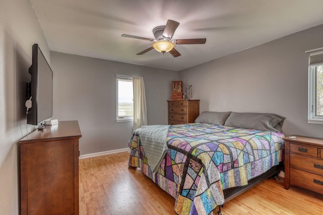 bedroom featuring light wood-type flooring, a ceiling fan, and baseboards