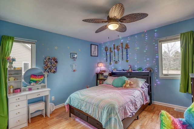 bedroom featuring wood finished floors, visible vents, and multiple windows