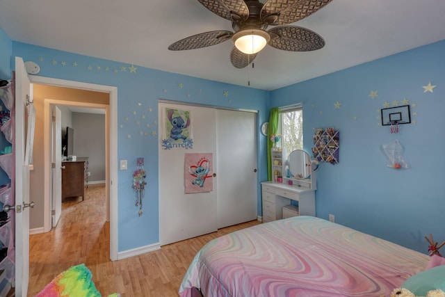 bedroom with a ceiling fan, baseboards, a closet, and light wood-style flooring