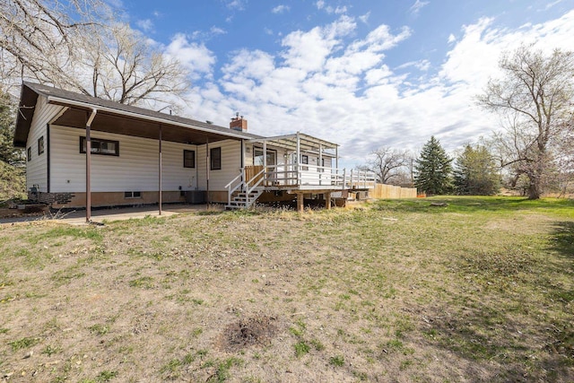 back of property featuring central AC unit, a chimney, a yard, and a deck