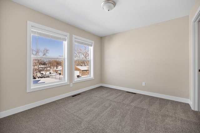 spare room with visible vents, carpet flooring, and baseboards