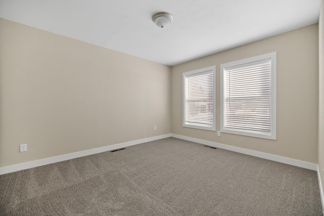 carpeted empty room with baseboards and visible vents