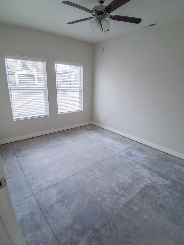unfurnished room featuring visible vents, baseboards, concrete floors, and ceiling fan