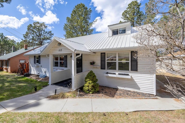 bungalow with a front yard and metal roof