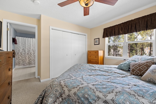 carpeted bedroom with baseboards, a ceiling fan, a textured ceiling, and a closet
