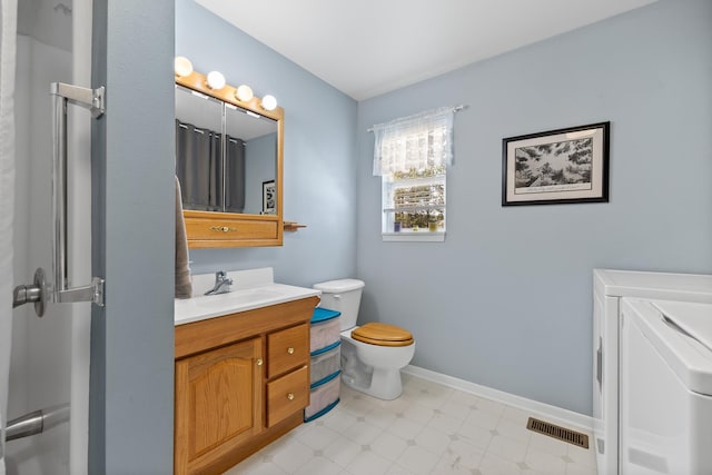 full bathroom featuring visible vents, toilet, vanity, baseboards, and separate washer and dryer