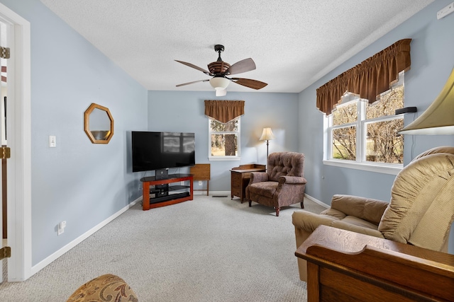 sitting room with carpet floors, a ceiling fan, a textured ceiling, and baseboards