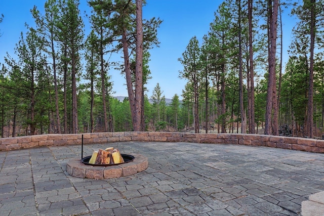 12388 Little Tiger Ln, Hill City, SD 57745 - view of patio / terrace featuring a fire pit and a forest view