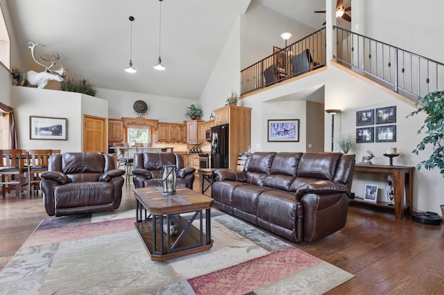 12388 Little Tiger Ln, Hill City, SD 57745 - living room with a ceiling fan, wood finished floors, high vaulted ceiling, and stairway