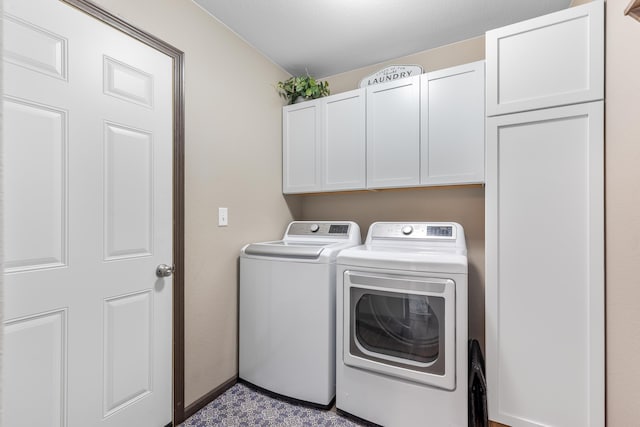 clothes washing area with washer and clothes dryer and cabinet space