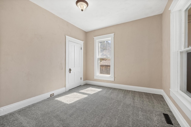 carpeted empty room featuring visible vents and baseboards