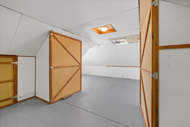 bonus room featuring concrete flooring and vaulted ceiling
