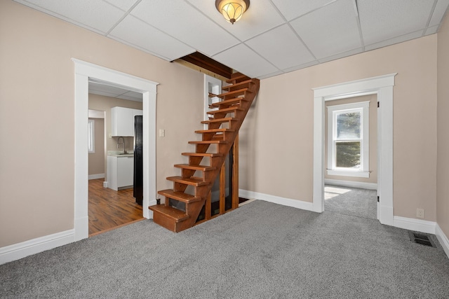 interior space with baseboards, visible vents, carpet floors, and a paneled ceiling