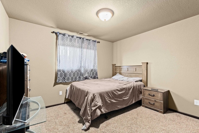 carpeted bedroom with a textured ceiling, visible vents, and baseboards