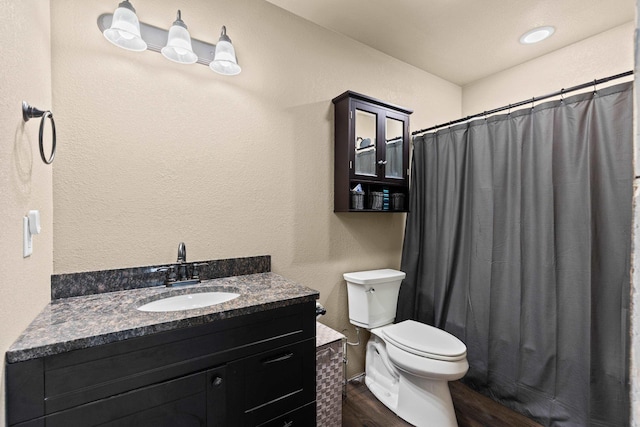 bathroom featuring wood finished floors, toilet, a shower with curtain, and vanity
