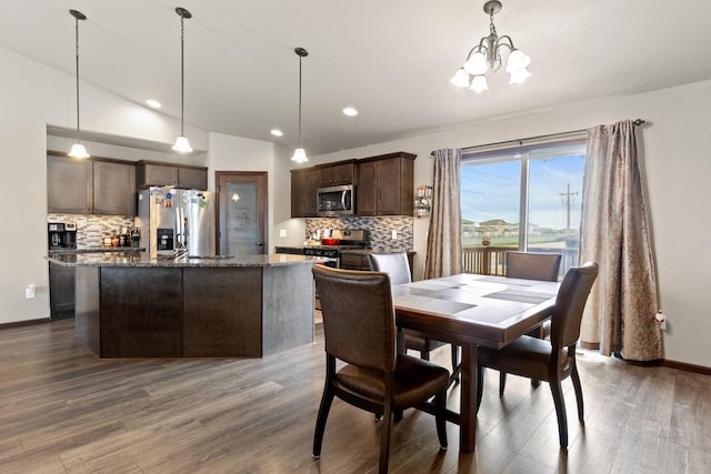 dining room featuring recessed lighting, an inviting chandelier, vaulted ceiling, baseboards, and wood finished floors