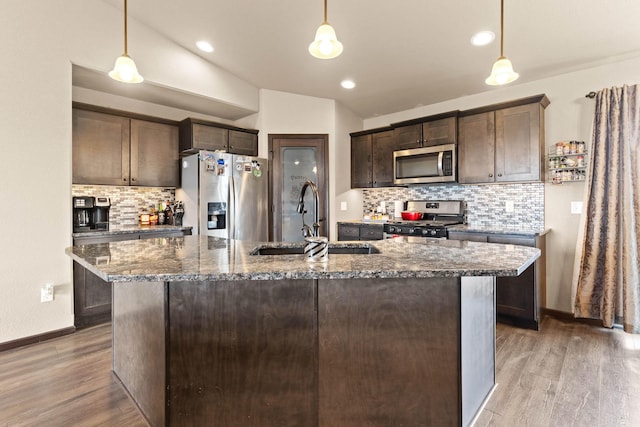kitchen with appliances with stainless steel finishes, dark brown cabinetry, decorative backsplash, and a sink