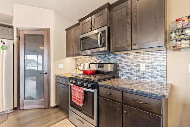 kitchen with light wood-style flooring, dark brown cabinets, appliances with stainless steel finishes, and tasteful backsplash