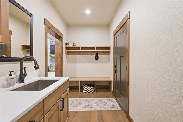 mudroom featuring recessed lighting, a sink, and wood finished floors