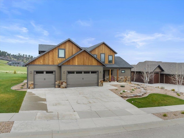 craftsman inspired home with a garage, concrete driveway, a front yard, and stone siding