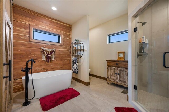 full bathroom featuring wood walls, toilet, a soaking tub, and a stall shower