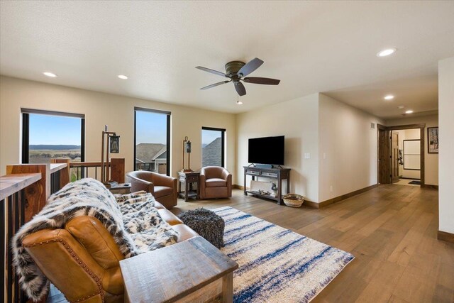 living room with a wealth of natural light, recessed lighting, and a ceiling fan