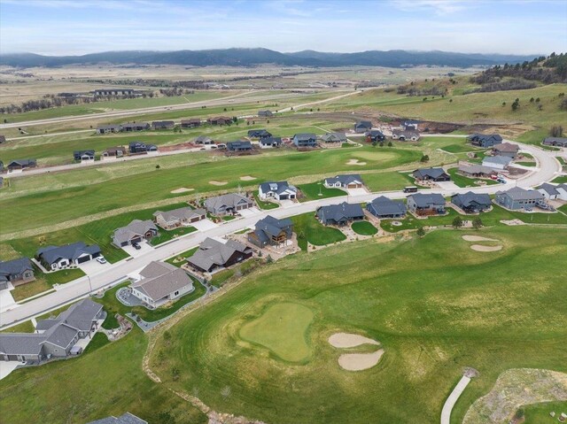 drone / aerial view featuring a mountain view, a residential view, and view of golf course