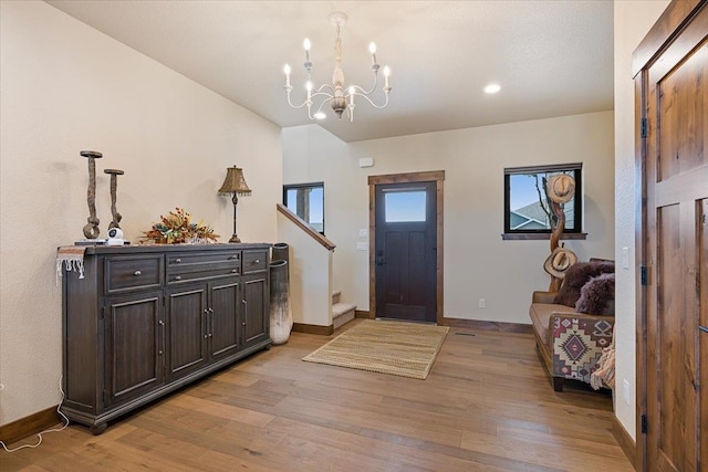 foyer entrance with recessed lighting, stairs, a chandelier, baseboards, and light wood-type flooring