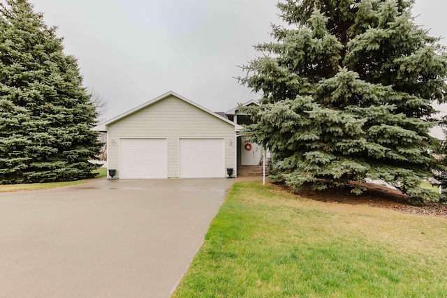 view of front facade with a front lawn, a garage, and concrete driveway
