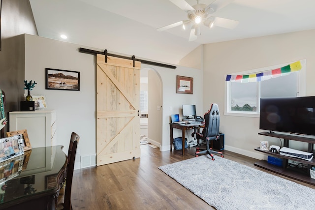 office space featuring baseboards, arched walkways, ceiling fan, and wood finished floors