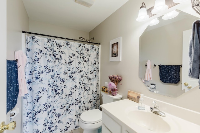 bathroom featuring vanity, toilet, and curtained shower