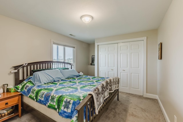 carpeted bedroom featuring baseboards and a closet