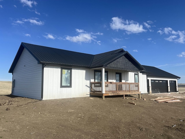 view of front of house featuring metal roof, a porch, a garage, and board and batten siding