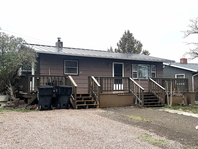306 10th Ave, Edgemont, SD 57735 - rear view of house featuring a chimney, a deck, a standing seam roof, and metal roof