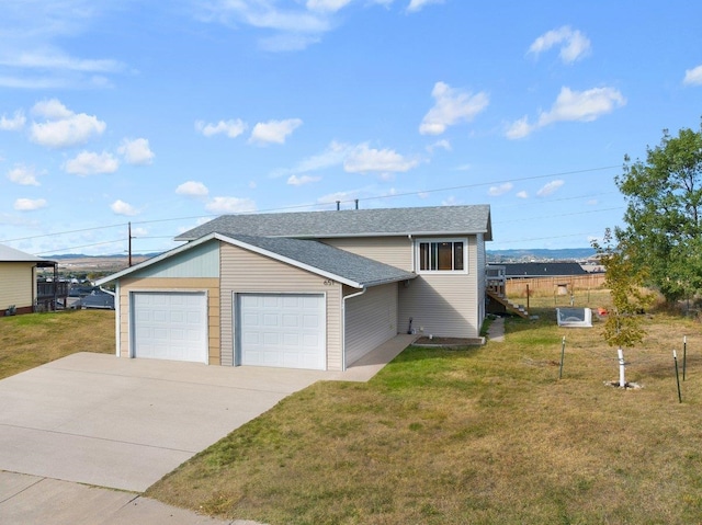 view of front of home with roof with shingles, a front yard, driveway, and an attached garage