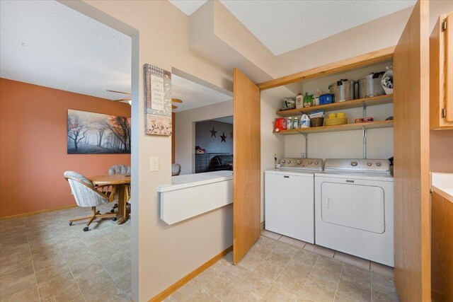 laundry room with laundry area, a textured ceiling, baseboards, and washer and dryer