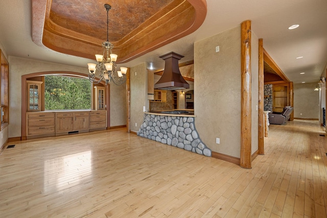 25189 Steckelberg Valley Rd, Custer, SD 57730 - unfurnished dining area featuring an inviting chandelier, visible vents, baseboards, a tray ceiling, and hardwood / wood-style flooring