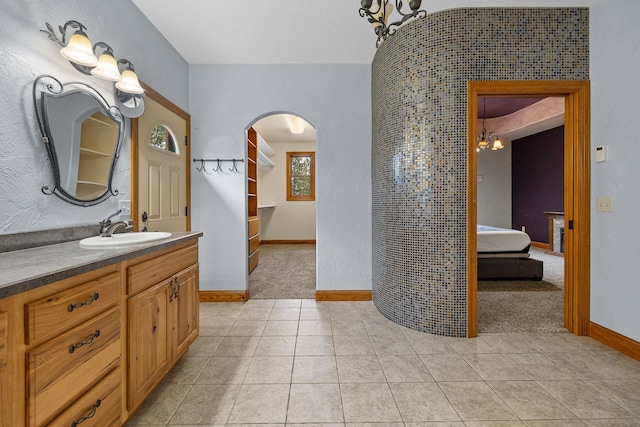 25189 Steckelberg Valley Rd, Custer, SD 57730 - bathroom featuring tile patterned flooring, vanity, baseboards, ensuite bath, and a notable chandelier