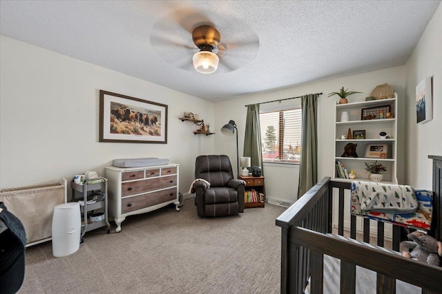 902 Yuma St, Belle Fourche, SD 57717 - carpeted bedroom with a nursery area, a ceiling fan, and a textured ceiling