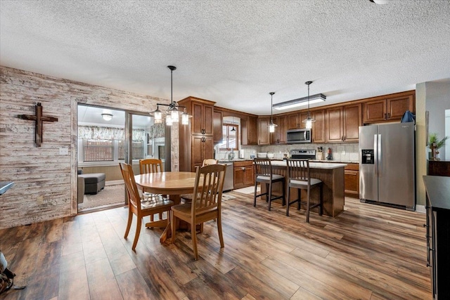 902 Yuma St, Belle Fourche, SD 57717 - dining space featuring a textured ceiling, wood finished floors, and a notable chandelier