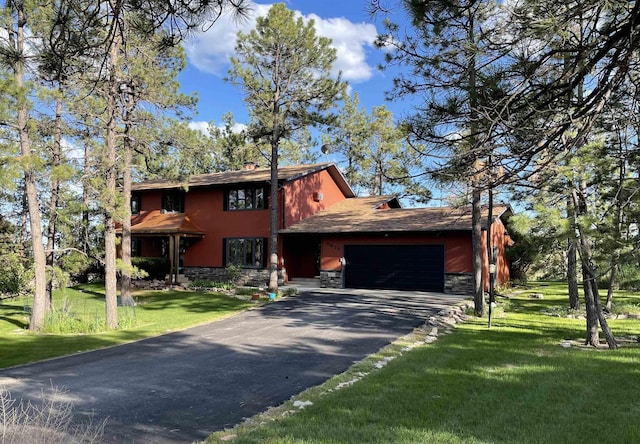 view of front of property featuring a garage, a front lawn, aphalt driveway, and stone siding