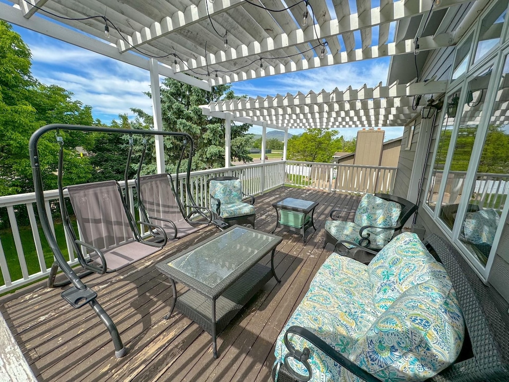 wooden terrace with a pergola and an outdoor living space