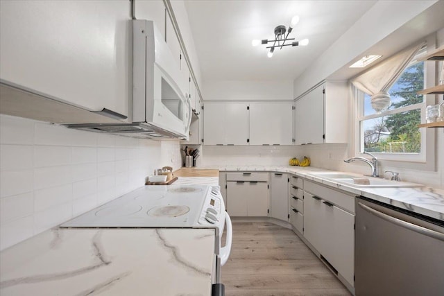 2042 12th Ave, Belle Fourche, SD 57717 - kitchen featuring stainless steel dishwasher, backsplash, a sink, and light wood finished floors