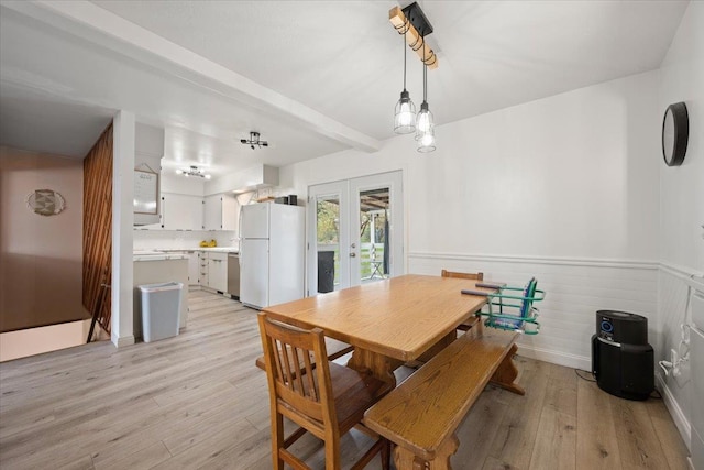 2042 12th Ave, Belle Fourche, SD 57717 - dining area featuring beam ceiling, french doors, light wood finished floors, and a wainscoted wall