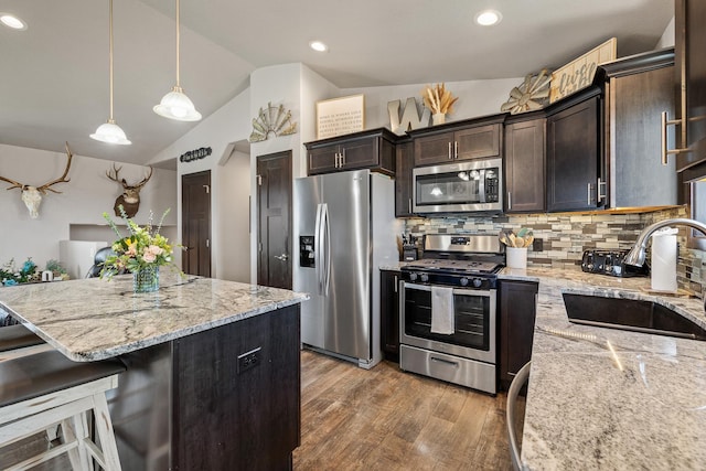 6461 Receda St, Rapid City, SD 57703 - kitchen featuring lofted ceiling, wood finished floors, a sink, backsplash, and stainless steel appliances