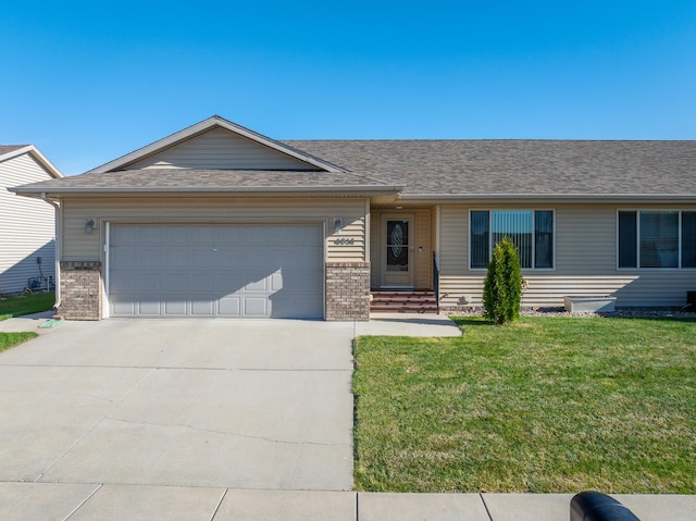 ranch-style home with a garage, a front lawn, roof with shingles, brick siding, and driveway