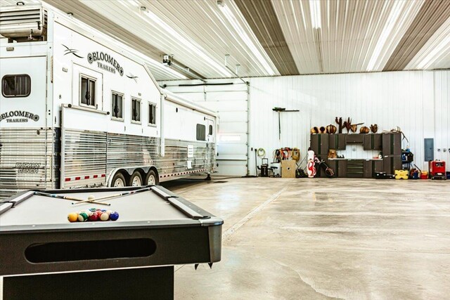 rec room with finished concrete flooring, pool table, and a garage