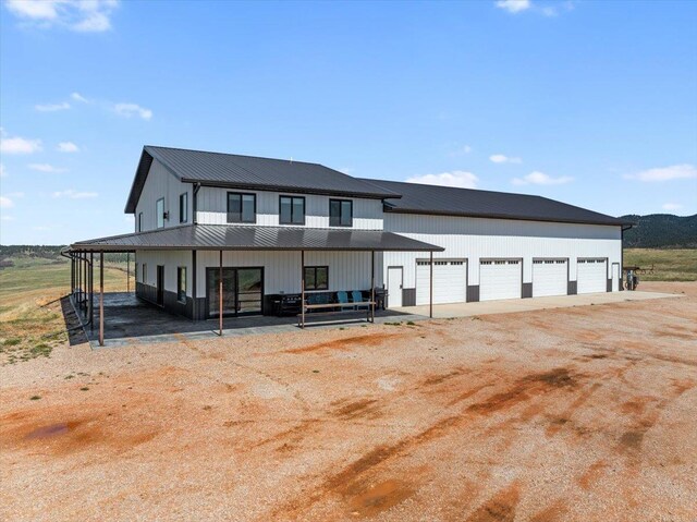modern farmhouse featuring dirt driveway, board and batten siding, a standing seam roof, and metal roof