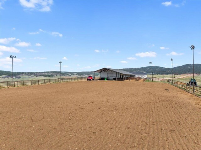 surrounding community with an exterior structure, an enclosed area, a mountain view, and a rural view